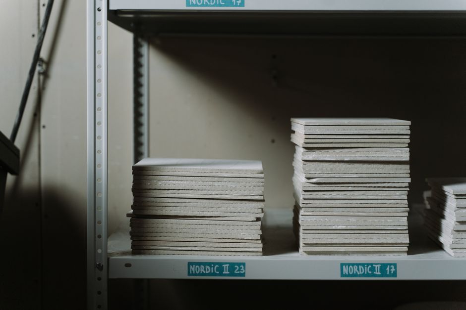 Stacked ceramic tiles and boxes in a Morbi factory warehouse representing tile manufacturing and ERP software