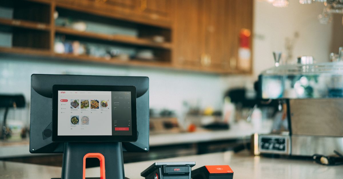 Cashier using restaurant billing and POS software on a tablet at a Bengaluru cafe counter